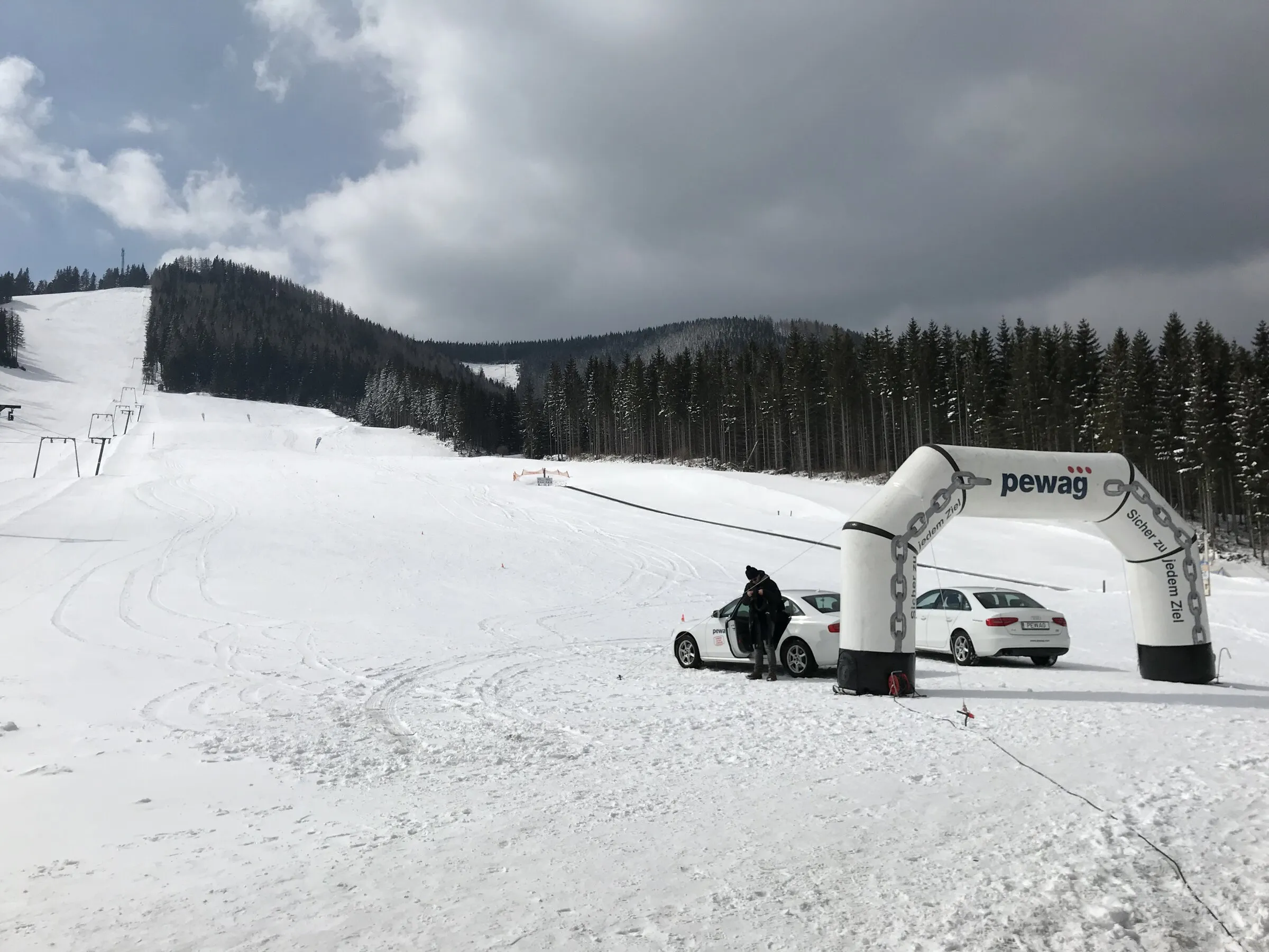 Pewag Servo snow test — Pewag branding at the end of the track with test vehicles